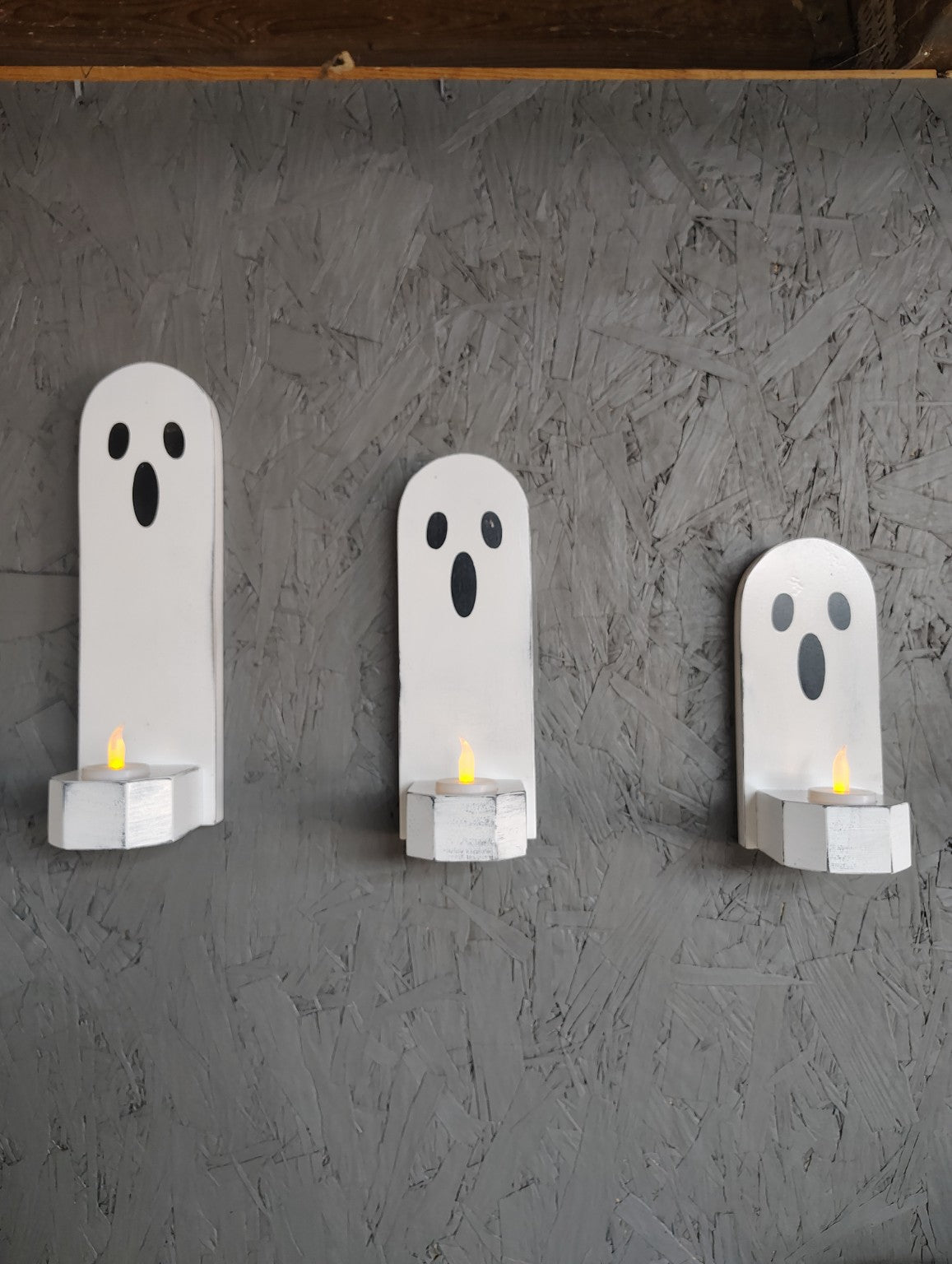 Three wooden ghost candle holders in graduated sizes