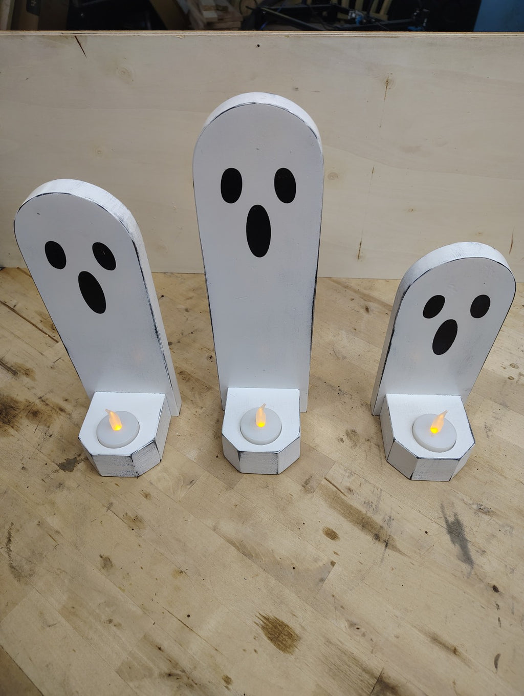 Set of 3 white wooden Halloween ghosts displayed on wood