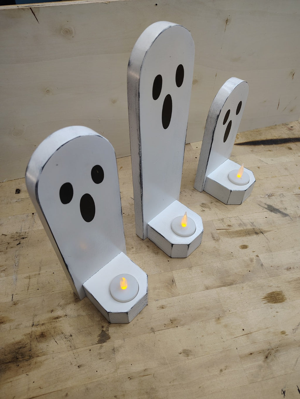 Handmade wooden ghost candle holders viewed from an angle