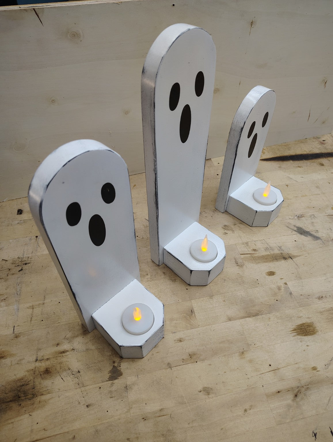 Handmade wooden ghost candle holders viewed from an angle